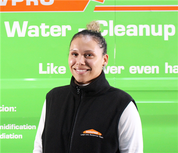 a woman in front of a green SERVPRO truck