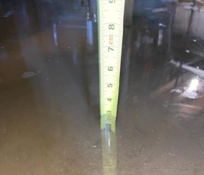 A ruler measuring the depth of standing water.