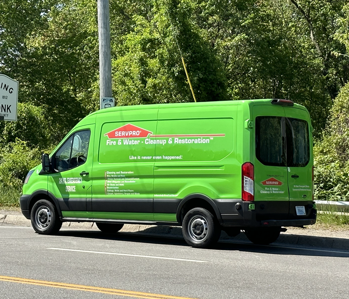 A green SERVPRO van on the road.